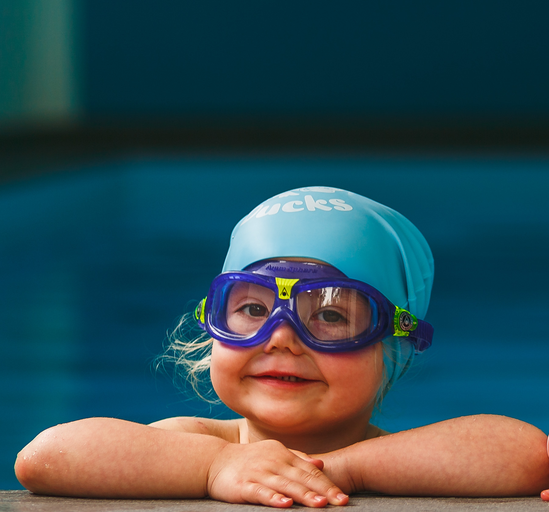 Smiling child in goggles swim, dive in the pool with fun - jump