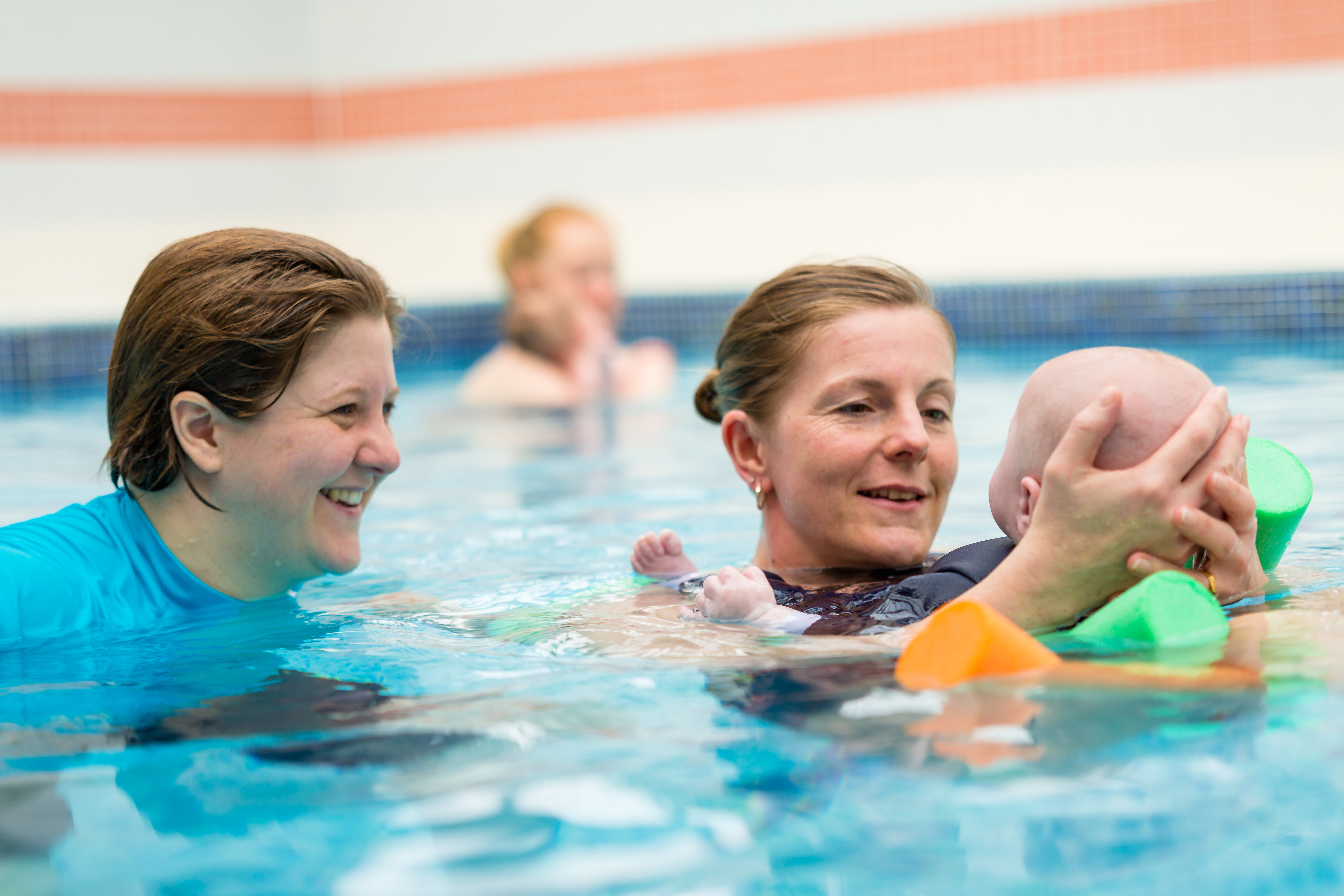 Teacher with a parent and baby in the water